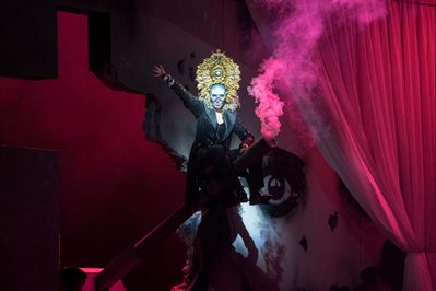 La Forza Del Destino Justina Gringyté Preziosilla Photo Credit Richard Hubert Smith 3724 Richard Hubert Smith Preziosilla sits, surrounded by pink smoke, right arm raised in the air.