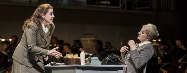 WNO The Consul Giselle Allen Madga Sorel Leah Marian Jones The Secretary Photo credit Johan Persson 840 Johan Persson 2019 Woman sat in front of desk other woman stood gesturing at her.