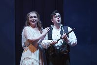 WNO The Magic Flute Anita Watson Pamina Ben Johnson Tamino Photo credit Bill Cooper 0940 Bill Cooper 2019 Man holds flute in his hands and woman has her hand on his shoulder smiling.