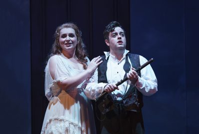 WNO The Magic Flute Anita Watson Pamina Ben Johnson Tamino Photo credit Bill Cooper 0940 Bill Cooper 2019 Man holds flute in his hands and woman has her hand on his shoulder smiling.