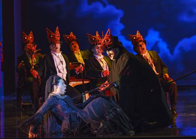 WNO Un ballo in maschera Mary Elizabeth Williams Amelia Jihoon Kim Samuel WNO Chorus Photo credit Bill Cooper© 0374 Bill Cooper 2019 Woman on floor being threatened with a sword by men with wolf masks.