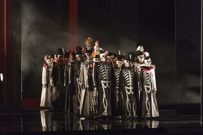 WNO Un ballo in maschera WNO Chorus Photo credit Bill Cooper© 0466 Bill Cooper 2019 Group dressed in skeleton costumes and face paint form a three wide line.