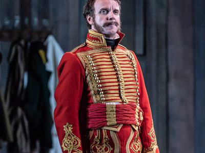 WNO War and Peace Adrian Dwyer Anatole Photo credit Clive Barda 0302 Clive Barda 2018 Anatole, dressed in red and gold, looks pensive.