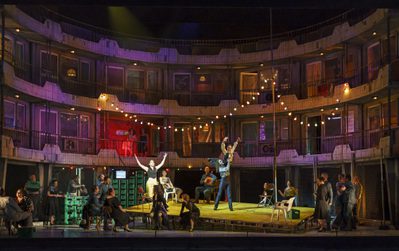 WNO Carmen Production Image Photo Credit Bill Cooper 1517 Bill Cooper 2019 Party scene with fairy lights man and woman dancing centurally with crowd watching.