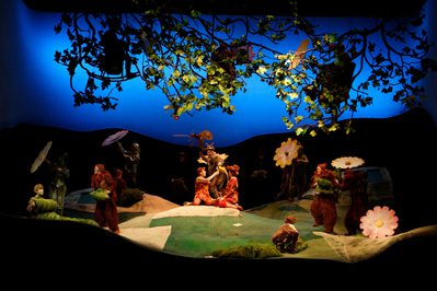 WNO The Cunning Little Vixen 2013 photo credit Catherine Ashmore 809 Image of cast in garden setting with plants and flowers surrounding
