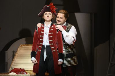 WNO The Marriage of Figaro Anna Harvey Cherubino and David Ireland Figaro Photo credit Richard Hubert Smith1603 Richard Hubert-Smith 2020 Soldier standing looking worried, other man has hands on his shoulders smiling.