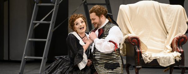 WNO The Marriage of Figaro Soraya Mafi Susanna and David Ireland Figaro Photo credit Richard Hubert Smith2618 Richard Hubert-Smith 2020 Couple kneeling on the floor holding hands looking happy.