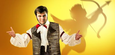 WNO 1000x486 Figaro A young man holds out his arms. The silhouette of a cherub shows on the yellow background.