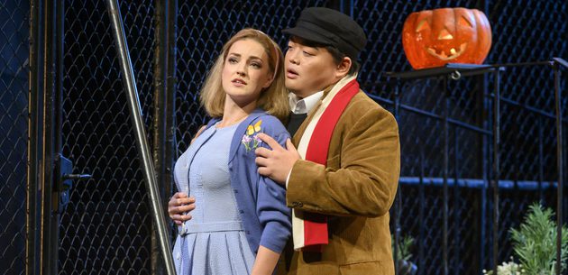 WNO Rigoletto 2019 Marina Monzo Gilda and David Junghoon Kim The Duke Photocredit Richard Hubert Smith 7536 Richard Hubert-Smith 2019 Woman in blue looks forward while man in cap stands behind her holding her waist