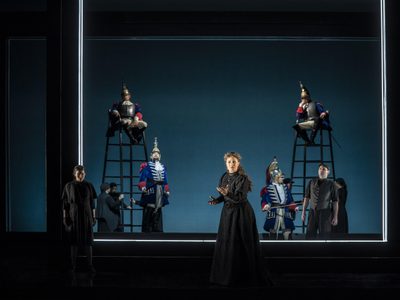 WNO Christine Byrne as Ninette Anush Hovhannisyan Robyn Lyn Evans as Danieli in Les vêpres siciliennes PHOTO CREDIT Johan Person 1050 Cast on stage with two men sitting on higher platforms