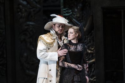WNO Don Giovanni Andrei Kymach Don Giovanni Marina Monzo Donna Anna photo credit Bill Cooper 0881 Don Giovanni, in white coat and hat, calms Donna Anna, in black mourning dress