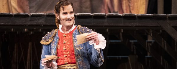 WNO The Barber of Seville Nicholas Lester Figaro photot credit Richa Figaro stood holding papers in hands