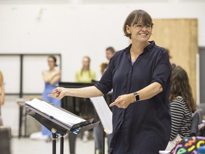 WNYO Cherry Town Moscow Alice Farnham Conductor photo credit Craig Fuller 39 Director Alice Farnham laughs, pointing at the libretto during a rehearsal