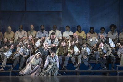 WNO Migrations The Mayflower WNO Chorus photo credit Craig Fuller 1 Sat on the benches, large group of people are thrown around, leaning left and right