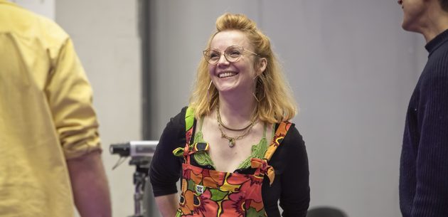 WNO The Magic Flute Daisy Evans Director photo credit Craig Fuller 5660 A women in a pair of floral dungarees smiles at a member of her cast