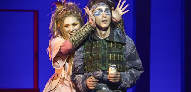WNO The Magic Flute Jenny Stafford Papagena Quirijn de Lang Papageno photo credit Craig Fuller 4961 A man in hunting equipment stands shocked whilst a women in a pink dress takes her hands from in front of his eyes