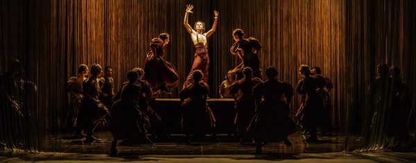 Isaac Tover as Bullfighter Dancer in WNO Ainadamar 2023 Credit Johan Persson 00953 A bullfighter stands bathed in yellow light, surrounded by women in typical Spanish dress