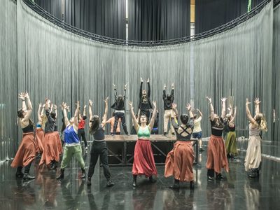 WNO Ainadamar Cast of Ainadamar photo credit Craig Fuller 4595 A female cast rehearse in the studio, stood in a circle and raising hands to the sky
