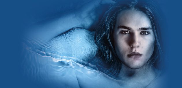 WNO CL1881 S24 Website image 1000x486 Cover Death in Venice A man with long hair looks at the character as he lies back with his arm next to his head against a blue background
