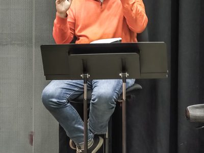 WNO Death in Venice Leo Hussain Conductor photo credit Craig Fuller 0553 A rehearsal shot of the conductor smiling whilst providing musical direction