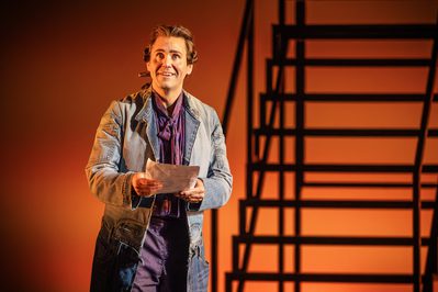 WNO Candide Ed Lyon Candide photo credit Craig Fuller 1167 Candide faces the audience, wide-eyed and with a hopeful smile on his face. In his hands he clutches a piece of paper.