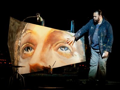 WNO Tosca Andrés Presno Cavaradossi Photo Credit Dafydd Owen 110 Cavaradossi stands to the right of his painted fresco, his hand hovering above Mary Magdalene's left eye. He wears a jacket splattered with paint.