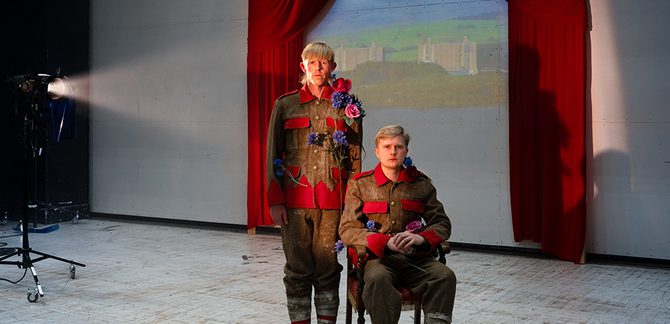 WNO 2627 Launch HW Cover Two men dressed in army gear and flowers stand in front of a projected image of Trawsmynydd Nuclear Station.